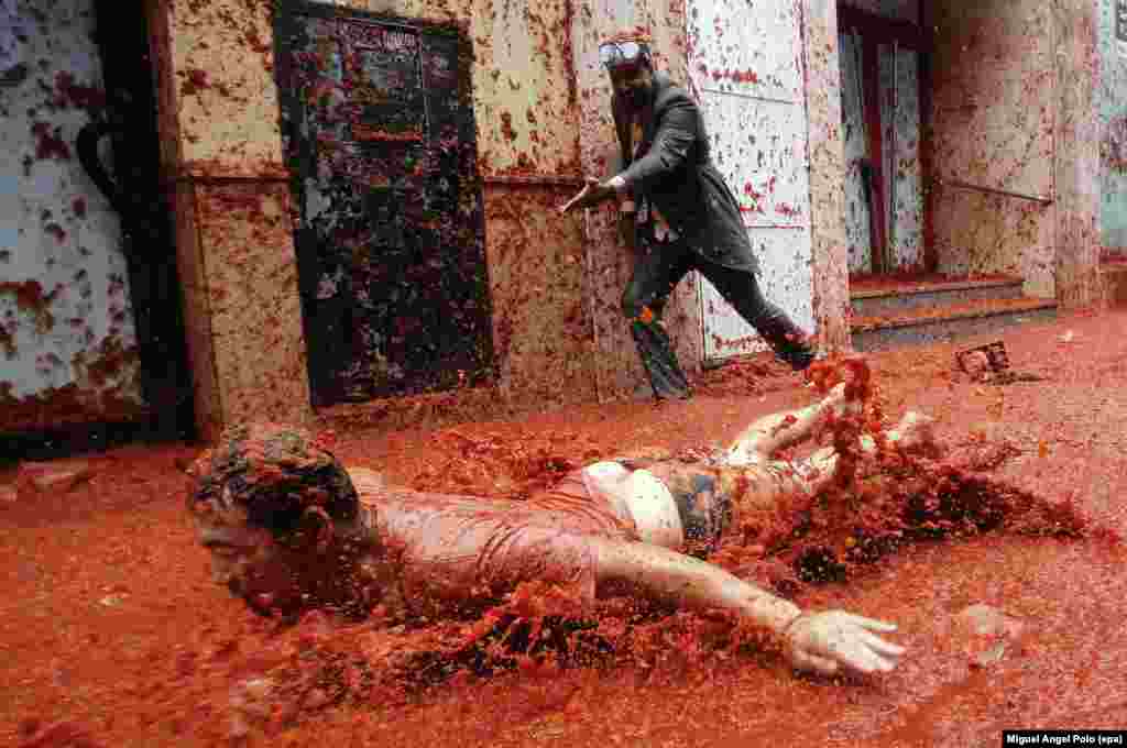 A man slides on the pavement covered with squashed tomatoes as he takes part in the traditional tomato fight called &quot;Tomatina&quot; in Bunol, Spain, on August 30. (epa-EFE/Miguel Aangel Polo)