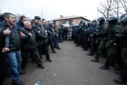 Demonstrators face off against Ukrainian law enforcement officers as they protest the arrival of a plane carrying evacuees from China's Hubei Province in the Ukrainian village of Novi Sanzhary on February 20.