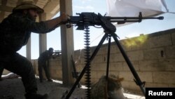 A Kurdish fighter fires a heavy machine-gun barrage at Islamic State militants in Raqqa on June 21