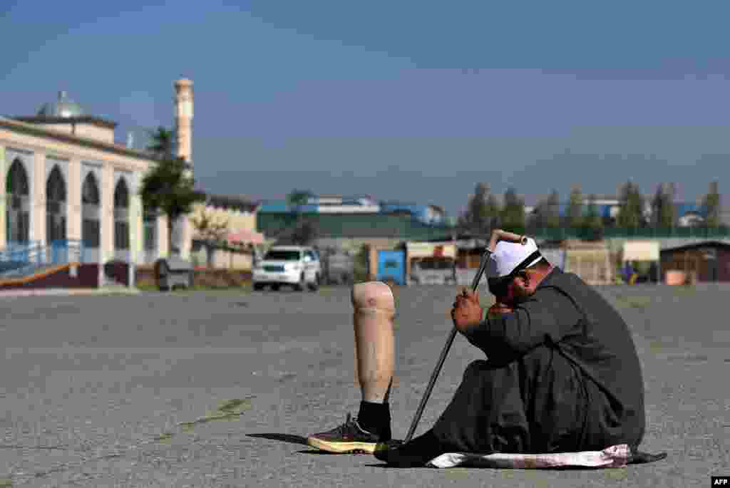 An Afghan man beg for alms after offering Eid al-Adha prayers at the Eid Gah Mosque in Kabul. (AFP/Wakil Kohsar)