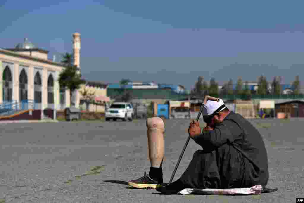 Owgan erkekgi Kabuldaky Eýd Gah metjidinde Gurbanlyk namazyny okap, köçede sadaka dileýär. (AFP/Wakil Kohsar)