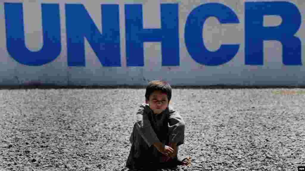 An Afghan refugee boy poses for a photograph as he waits to leave with his family for Afghanistan, at a UN refugee center on the outskirts of Peshawar, Pakistan. (epa/Bilawal Arbab)