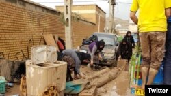 People trying to dig out of a thick layer of mud left by days of floods in Lorestan province. APRIL 4, 2019