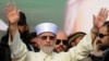 Muhammad Tahir-ul-Qadri waves to supporters on his arrival in Lahore on December 23.