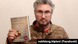 Ukrainian historian Vakhtang Kipiani in the uniform of the armed forces of Ukraine and with his book The Case Of Vasyl Stus.