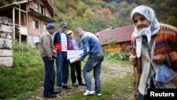 Bosnian Muslims speak with a survey taker during Bosnia's first census in the village Krusev Do, near Srebrenica, in October 2013.