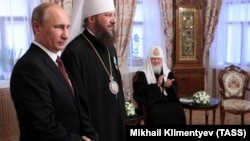 Președintele rus Vladimir Putin decorându-l pe Mitropolitul Antonie, de la Biserica Ortodoxă Ucraineană (subordonată Patriarhiei ruse) la Kiev, în iulie 2013. Peste mai puțin de un an, Rusia anexa ilegal Crimeea.