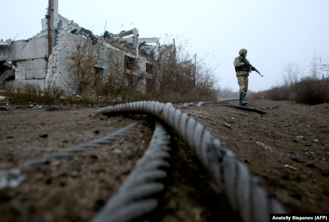 Український військовослужбовець біля знищеної вугільної шахти «Бутівка» на лінії фронту недалеко від Авдіївки