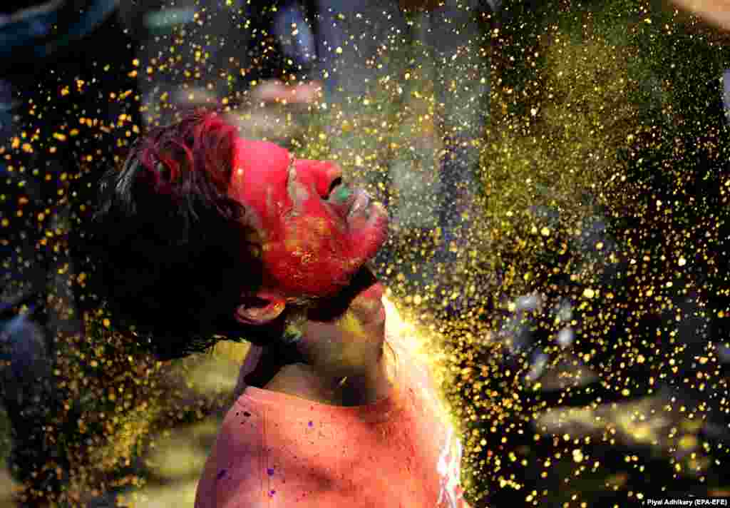 Locals apply colored powder on each other during Holi festival celebrations in Kolkata, India. (epa-EFE/Piyal Adhikary)&nbsp;