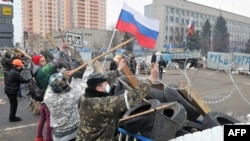 Pro-Russian activists reinforce their barricade outside the regional Security Service building in the eastern city of Luhansk on April 10.