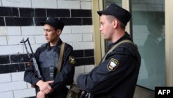 Озброєні автоматичною зброєю поліцейські стоять біля входу до помешкання Олексія Навального, 11 червня 2012 року