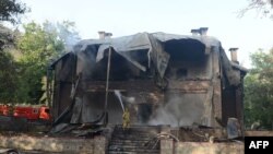 FILE: A Pakistani firefighter extinguishes a blaze which gutted a historical building in Balochistan's Ziarat region in 2013.