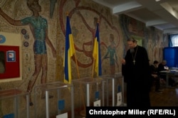 A Moscow Patriarchate cleric of the Kyiv Pechersk Monastery casts his ballot at a polling station inside Kyiv's School No. 90 early on April 21.
