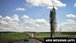 A Russian mortar shell lands near the road leading to the city of Lysychansk in the Donbas as a car passes on May 23.