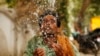 Indijski radnik prska vodom lice da se rashladi u vrelo ljetno popodne u Prayagraju, Uttar Pradesh, Indija, fotoarhiv