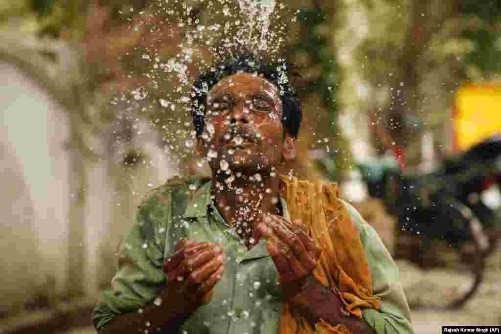 An Indian worker splashes water on his face on a hot summer afternoon in Prayagraj, Uttar Pradesh, India. Severe heatwave conditions are sweeping north and western parts of India with maximum temperature soaring to 48 degrees Celsius in some areas. (AP/Rajesh Kumar Singh)