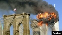 Здания Всемирного торгового центра охвачены огнем после атаки террористов. Нью-Йорк, 11 сентября 2001 года. 