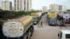 Men walk past fuel tankers, used to transport fuel to NATO forces in Afghanistan, parked near oil terminals in the Pakistani port city of Karachi.