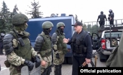 Lukashenka clutches his AKS-74U as he greets riot police near the Palace of Independence in Minsk on August 23.