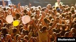 Generic -- Yellow lighted arded crowd at a live concert of a famous rockband