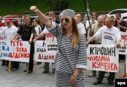 A woman dressed as a prisoner shouts slogans during a protest against government corruption demanding the resignation of officials who worked under ousted President Viktor Yanukovych, in Kyiv in 2014.