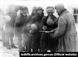 Fénykép a harmincas évekbeli ukrajnai holodomor időszakából a donyecki régióból: kölest kapnak a kolhozban dolgozó parasztok. Az éhínséget a sztálini politika számlájára írták; a Memorial nem akarta, hogy ez feledésbe merüljön