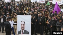 Protesters hold a poster of Iraqi Finance Minister Rafia al-Issawi during a demonstration calling for Prime Minister Nuri al-Maliki's resignation in the western city of Falluja in December.