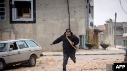 Человек бежит в укрытие во время вчерашнего обстрела Мисураты войсками Муамара Каддафи