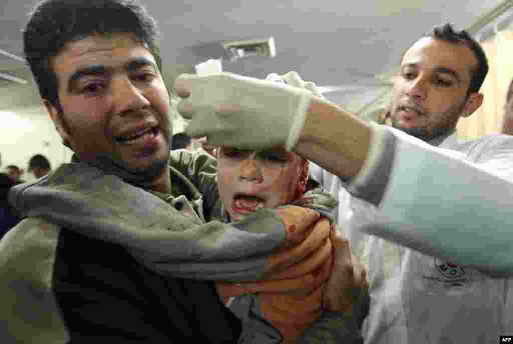 Раненный мальчик на руках у своего отца в одном из госпиталей Газы, 28 декабря 2008