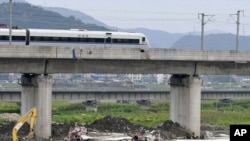 A bullet train passes the viaduct from which carriages fell in the crash near Wenzhou, east Zhejiang Province, on July 25.