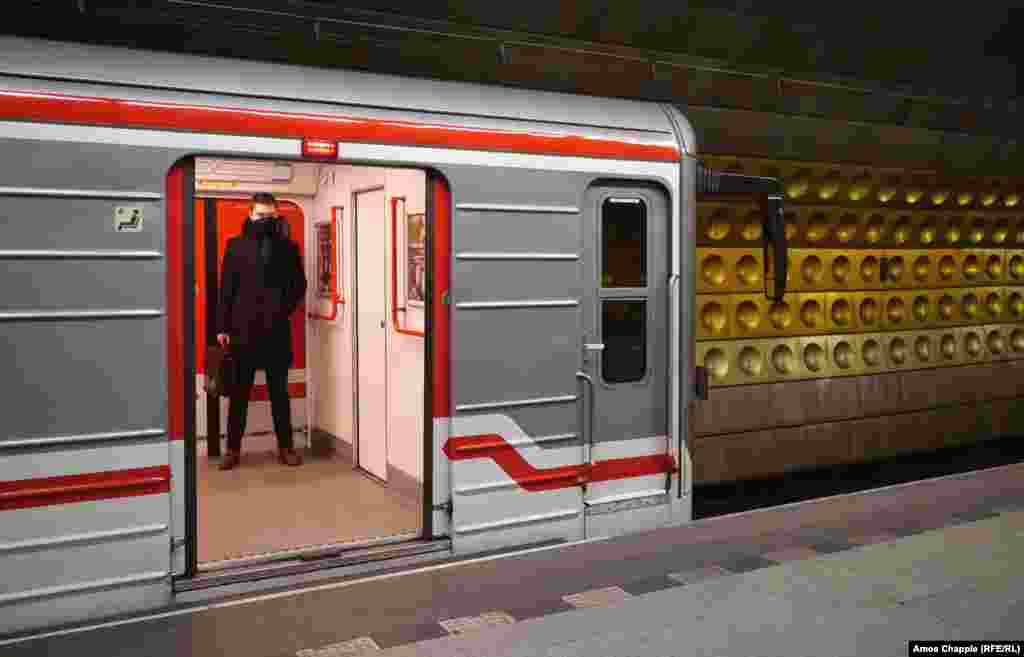 Мужчина в пустом вагоне метро на станции рядом с туристическим центром Праги.