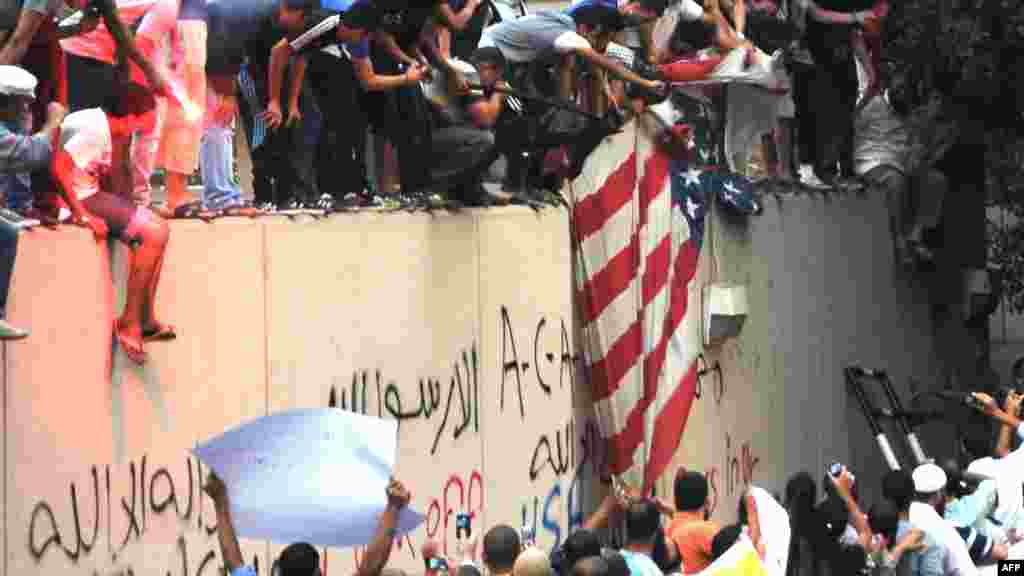 Protesters tear down a U.S. flag at the U.S. Embassy in Cairo, Egypt, after the outbreak of violence over a privately made film that mocks the Prophet Muhammad. (AFP)