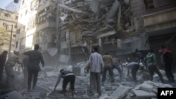 Syrian civilians and rescuers gather at site of air strikes by government forces in the rebel-held neighborhood of Al-Shaar in Aleppo on September 27. 