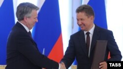 Gazprom's chief executive, Aleksei Miller (right), exchanges documents with Shell CEO Ben van Beurden during a signing ceremony for a joint venture in St. Petersburg on June 16. 