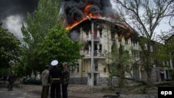 Өртеніп жатқан милиция ғимараты қасында тұрған адамдар. Мариуполь, Укрина, 9 мамыр 2014 жыл.