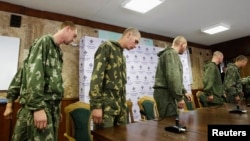 A group of Russian servicemen, who were detained by the Ukrainian authorities in southeastern Ukraine, arrive at a news conference in Kyiv on August 27.