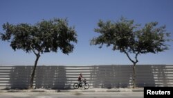 Dječak vozi bicikl u Izraelskom naselju Beitar Ilit, na Zapadnoj obali. Beitar Ilit je izgrađen za ultraortodoksnu jevrejsku zajednicu 1990-ih i jedno je od najvećih naselja koje se najbrže širi. Zapadna obala, juli, 2019. 