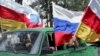 People wave Russian and South Ossetian flags in Tskhinvali, the South Ossetia capital, after Russia recognized the region as independent.