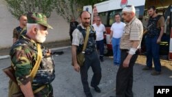 Armenia -- A picture taken on July 17 and made available on July 19 shows armed men standing by an ambulance car at the yard of Erebuni police station in Yerevan seized by them.