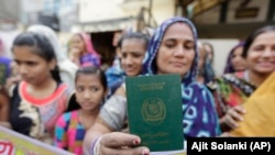 Refugiată hindusă din Pakistan arătându-și pașaportul în cursul unui protest pentru adoptarea noii legi a cetățeniei din India, decembrie 2019.
