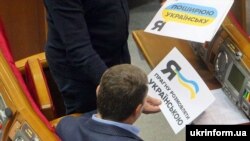 Один із депутатів у Верховній Раді в День української писемності та мови демонструє колезі листівки. Київ, 4 листопада 2016 року