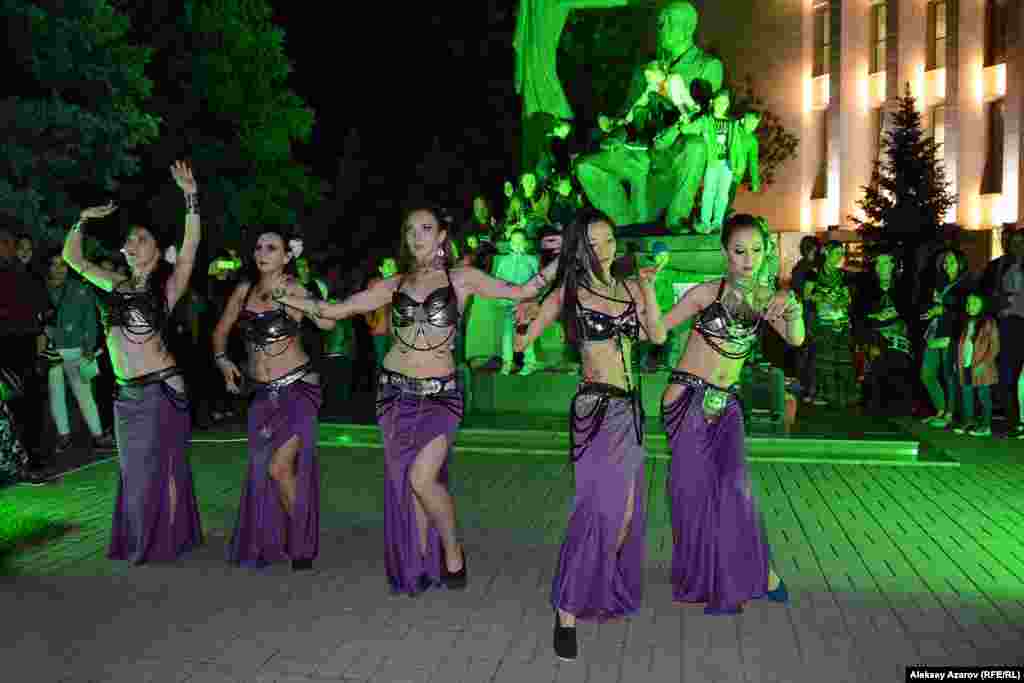 А эта танцевальная группа девушек выступала перед памятником народному художнику Казахстана Абылхану Кастееву.