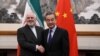 China's Foreign Minister Wang Yi (R) shakes hands with Iran's Foreign Minister Mohammad Javad Zarif during their meeting at the Diaoyutai State Guest House in Beijing on December 31, 2019.