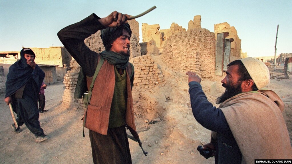 A Taliban militant attacks a civilian in Kabul in 1996. (file photo)