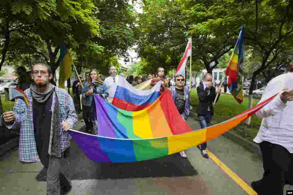 Members of the LGBT community carry a rainbow-colored flag as they attend a march for human rights and equality in Chisinau, Moldova, on May 17. (epa/Dumitru Doru)