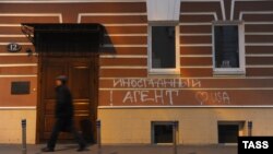 Мужчина у здания с надписью «Иностранный агент» на стене. Москва, 21 ноября 2012 года.