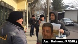 Байболат Кунболатулы с портретом своего брата, который, по словам Байболата, удерживается под стражей в Синьцзяне.