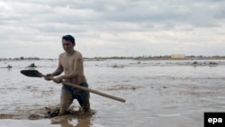 A man wades through flooding on April 25 after heavy downpours triggered flashfloods in Sheberghan, Afghanistan.