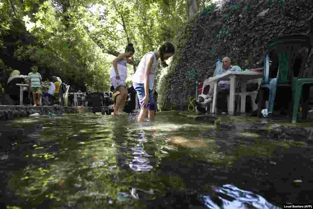 Girls soak their feet at a leisure area in the regime-held port city of Tartus in northwestern Syria. (AFP/Louai Beshara)