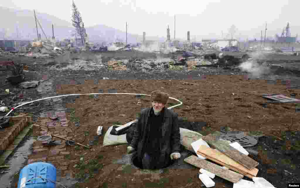 A local resident surveys the damage to the settlement of Shyra caused by recent deadly wildfires in the autonomous Russian region of Khakassia. (Reuters/Ilya Naymushin)